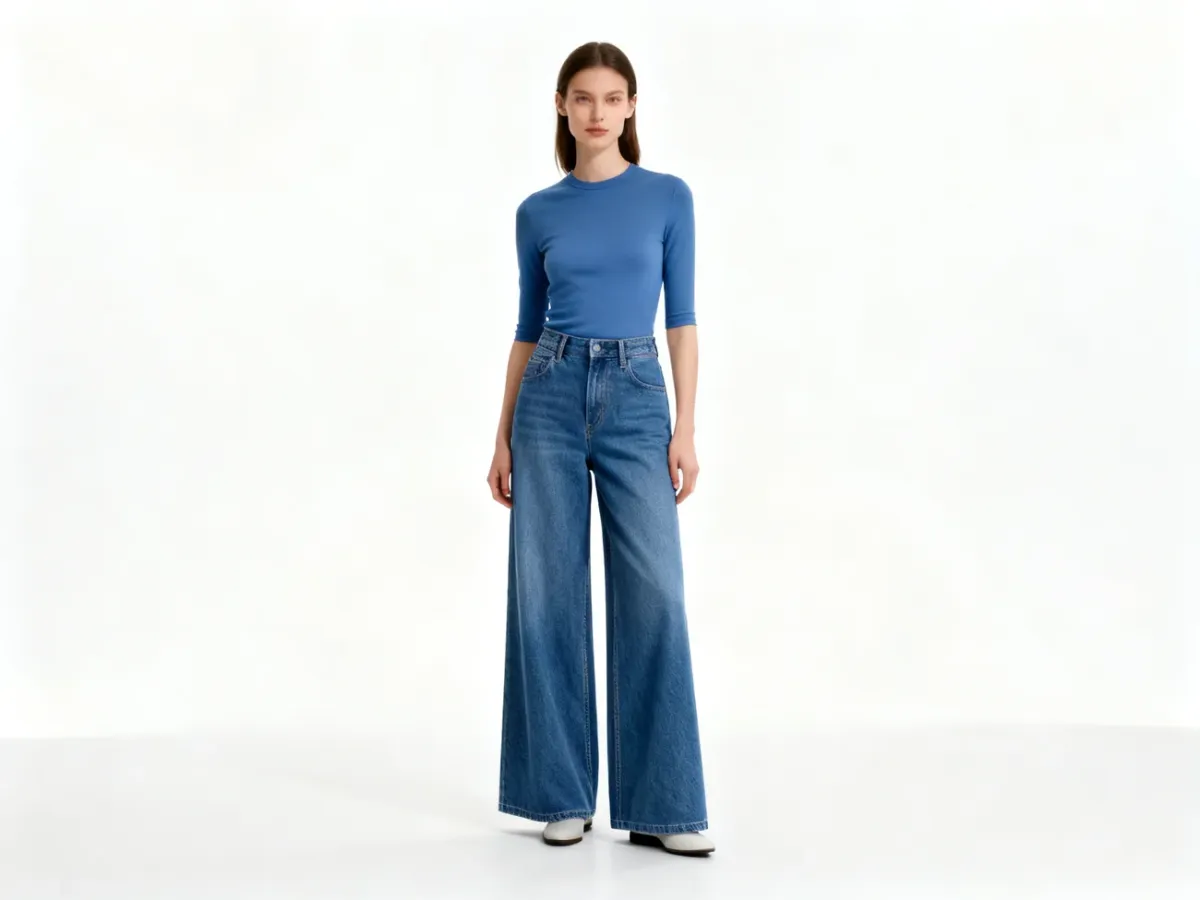 Kobieta w szerokich jeansach wide leg podkreślających długą, prostą linię nóg