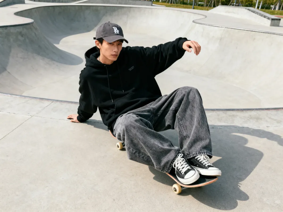 Oversize stylizacja z jeansami baggy, bluzą i czapką na skateparku